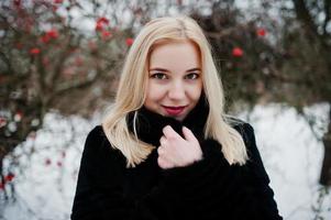 chica rubia posó en el día de invierno cubierto de nieve. foto