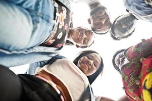 Group of five african college students spending time together on campus at university yard. Black afro friends studying. Education theme. View from down. photo