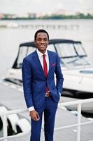 African american happy successful man at suit against yacht. Rich black business man. photo