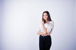 Portrait of an elegant young woman in white top and black pants in the studio. photo