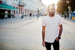 Stylish indian beard man at pink t-shirt. India model posed outdoor at streets of city sunset. photo