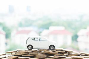 Little car over a lot of money stacked coins with background house. for loans costs finance concept. with filter Tones retro vintage effect ,Warm tones. photo