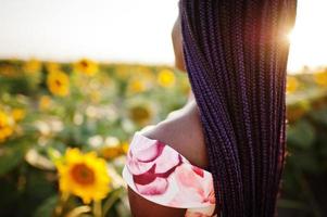 Pretty young black woman wear summer dress pose in a sunflower field. photo