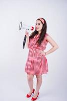 Portrait of a young beautiful woman in red dress talking into megaphone. photo