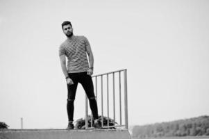 Handsome tall arabian beard man model at stripped shirt posed outdoor at skate park. Fashionable arab guy. photo