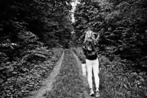 Portrait of a young beautiful blond woman in tartan shirt holding a map in the forest. photo