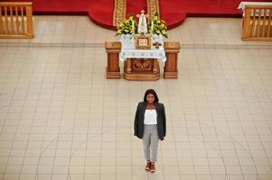 mujer afroamericana rezando en la iglesia. los creyentes meditan en la catedral y tiempo espiritual de oración. vista desde arriba. foto