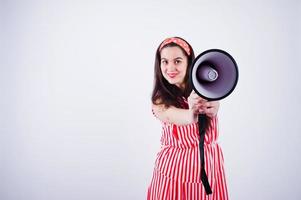 Portrait of a young beautiful woman in red dress talking into megaphone. photo