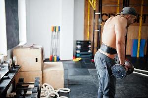 Fit and muscular arabian man doing workouts in gym. photo