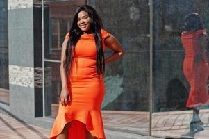 mujer afroamericana modelo xxl en vestido naranja. foto