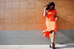 mujer afroamericana modelo xxl en vestido naranja. foto