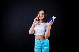 retrato de una mujer feliz posando con pasaporte y teléfono inteligente. foto