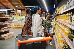 Group of african womans buying sunflower oil bottle in supermarket. photo