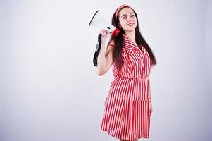 Portrait of a young beautiful woman in red dress talking into megaphone. photo