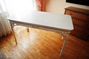 mesa tallada en madera blanca en piso. foto