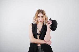 Studio portrait of blonde girl in black wear and cap against white background. photo