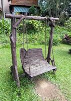The old wooden swing with the metal chain for playing in the garden. photo