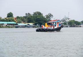 A tug boat is towing the large cargo boat. photo