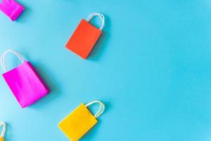 Minimal shoping online concept, Colorful paper shopping bag go down from floating pink background for copy space. Customer can buy everthing form home and the messenger will deliver. photo