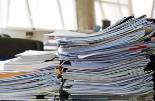 Documents pile on the table in office photo