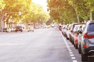 aparcamiento de coches aéreos al aire libre, coches traseros en fila aparcados al lado de la carretera. carretera de semáforos de fondo y sin atascos de tráfico. concepto de transporte foto