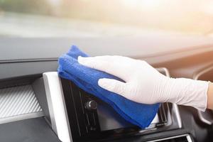 A worker hand wear glove cleaning car console steering wheel with microfiber cloth,  car wash detailing concept. photo
