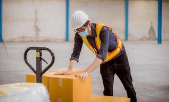 Factory engineer under inspection and checking quality production process on face mask manufacture  station by  wearing casual uniform and safety helmet in factory plantation. photo