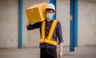 Factory engineer under inspection and checking quality production process on face mask manufacture  station by  wearing casual uniform and safety helmet in factory plantation. photo