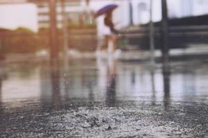 gotas de lluvia en el agua pesada sobre sombra de asfalto de sombra negra y reflejo del cielo oscuro en la ciudad. alto contraste durante el otoño foto