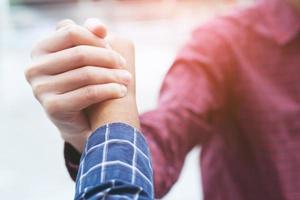 Closeup of a business man hand shake between two colleagues greet , Represents Friendship is good,success, congratulations. outdoor of building background. copy leave space for text. photo