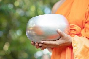 monk with hand holding give alms bowl which came out of the offerings in the morning at Buddhist temple, Culture Heritage Site tradition and Religion Buddhism ,South east asia. photo