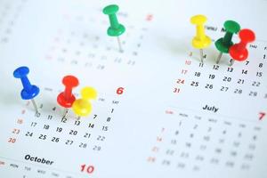 mark the event day with a pin. Thumbtack in calendar concept for busy timeline organize schedule,appointment meeting reminder. planning business meeting or travel holiday planning concept. soft focus photo