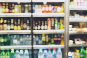 foto productos de bebidas borrosas bebidas botellas de refrescos en el refrigerador del supermercado variedad de bebidas en los estantes en el fondo de la tienda de conveniencia. difuminar dejar copia espacio vacío para escribir texto