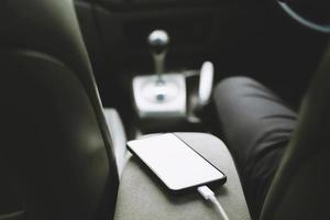 cargar la batería del teléfono en el coche. Coloque el teléfono inteligente móvil en el coche. foto