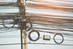 Messy electrical cables and wires on electric pole photo