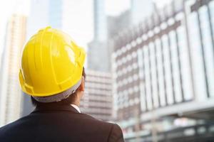 Close up engineers working on a building site holding a blueprints photo