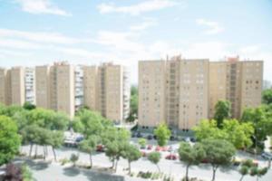 photo blurred facade of a modern condominium apartment building multi-story city sky cloud at Shady trees background, front area next to the road and Parking car. Living Concepts and Town Planning