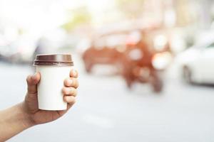 maqueta de mano masculina sosteniendo una taza de papel de café aislada foto