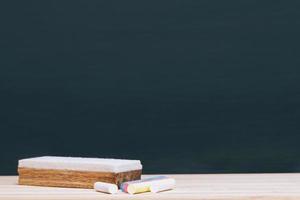 Blank Dark blackboard with Chalk and eraser on the frame for drawing in Classroom. Horizontal composition. copy space empty Chalkboard Background. back to school. education photo