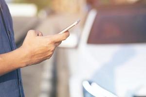 close up hand people man stand using the mobile smart phone in the roadside wayside. call a car mechanic ask for help assistance because car broken. photo
