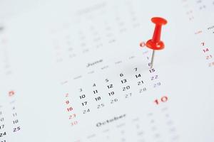 mark the event day with a pin. Thumbtack in calendar concept for busy timeline organize schedule,appointment reminder. planning business meeting or travel holiday planning concept. soft focus photo