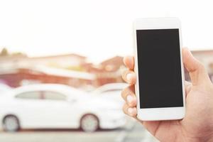 cerrar la mano de un hombre de negocios usando un teléfono inteligente móvil llamar a un mecánico de automóviles pedir ayuda porque el automóvil se rompió en la carretera. la gente viaja amigos de pie esperando al lado del fondo del coche roto. foto