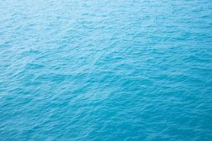 olas del mar en las olas del océano salpicando agua ondulada. fondo de agua azul. foto