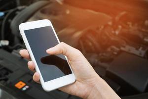 close up young business man hand using a mobile smart phone call a car mechanic ask for help assistance because car broken on the roadside. blank if empty screen photo