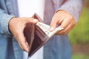 Hipster man hands holding wallet with credit cards and stack of money photo