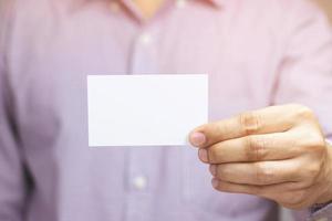 las tarjetas de visita del asimiento de la mano del hombre de la gente muestran la maqueta de la tarjeta blanca en blanco. Frente de exhibición de tarjeta de crédito o cartón. concepto de marca comercial. foto