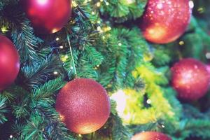 Closeup of bauble colorful variety hanging from a decorated christmas tree on blurred of lights with decorated tree, sparkling and bokeh background. copy space for your text. Christmas Tree Decoration photo