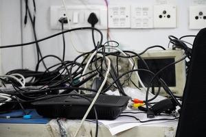 concepto de desorden en los cables eléctricos de la oficina sobre la mesa foto