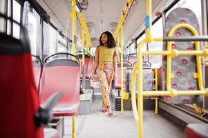 Young stylish african american woman riding on a bus. photo