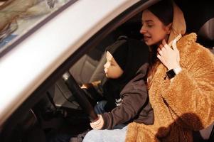 joven madre e hijo en coche. concepto de conducción segura. foto